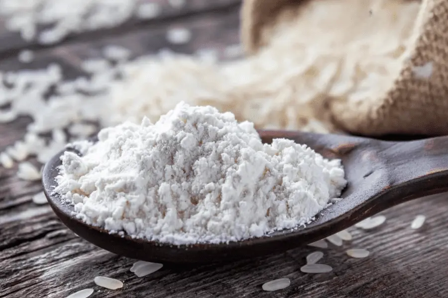 Cuchara con un poco de harina sin gluten en específico la harina de arroz sobre una mesa