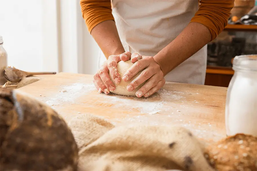 Manos de mujer panadera amasando una masa para pan