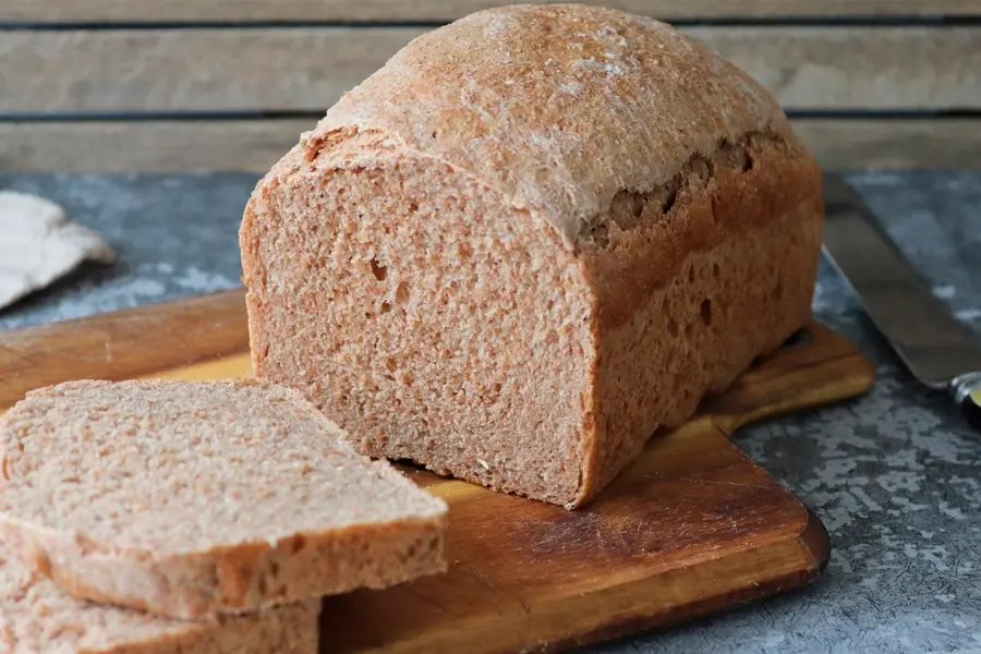 Pan de espelta integral siendo cortado en rebanadas