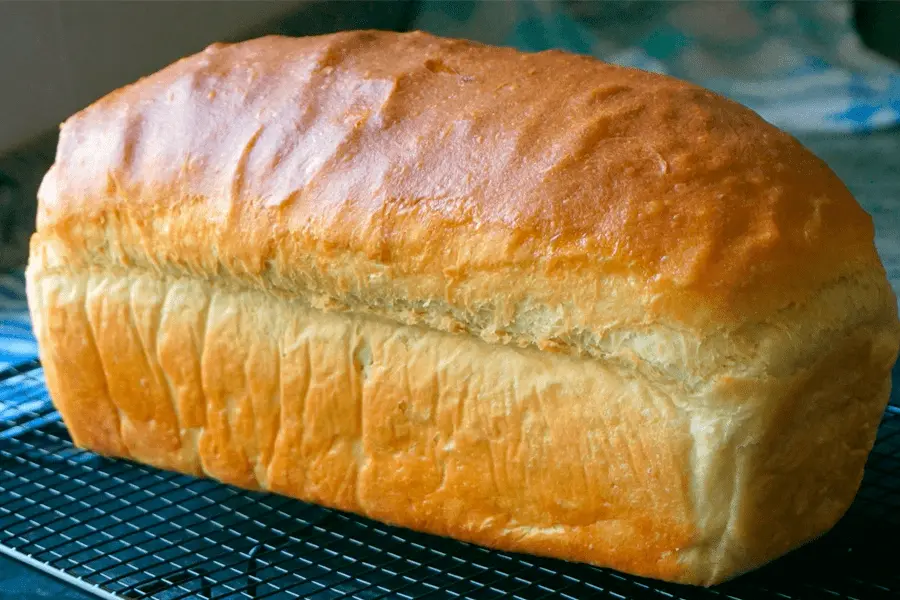 Pan de molde colocado sobre una rejilla de enfriamiento en una cocina