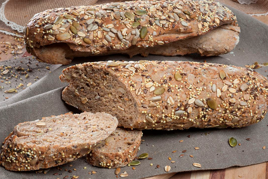 Pan de multicereal siendo cortado en rebanadas