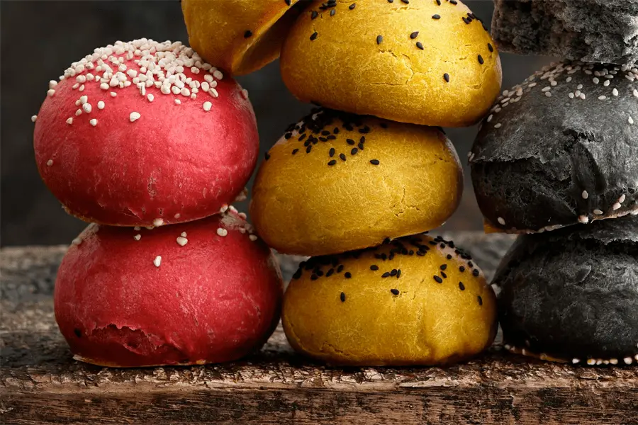 Diferentes bollos de colores apilados sobre una mesa