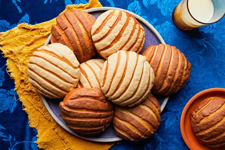 Diferentes panes de concha apiladas en un plato sobre una cocina doméstica