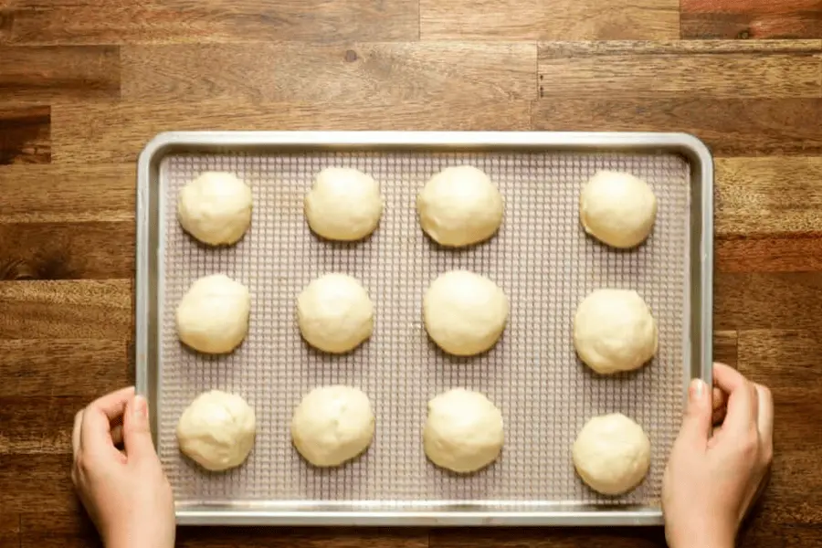 Masa de bollos rellenos en una charola a punto de ser horneados