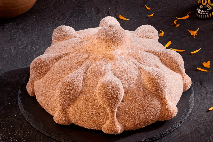 Pan de muerto colocado sobre un plato de color negro