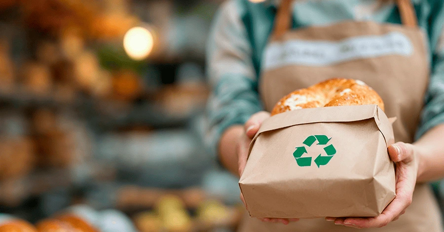 Mujer panadera entregando sus panes en empaques biodegradables y reciclables